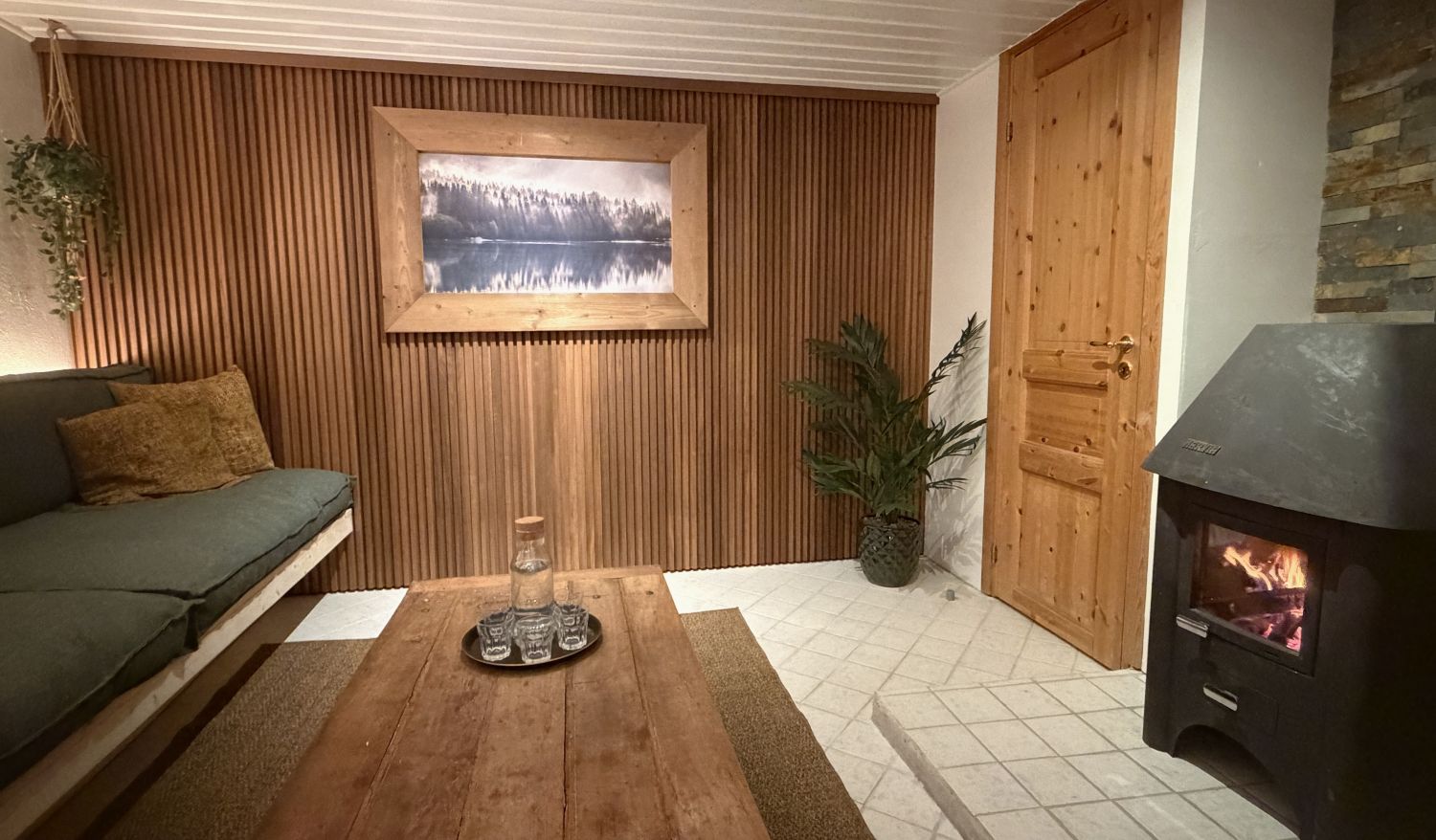 Cozy sauna relaxation room with wood burning stove at Lappvall Lodge